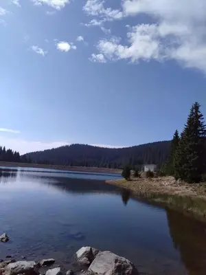 a large body of water with trees in the background at Пампорово Студио М хотел в Росица in Pamporovo