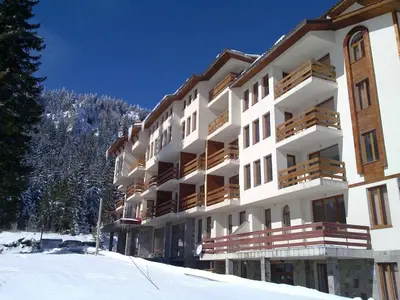 a large building with snow in front of it at Пампорово Студио М хотел в Росица in Pamporovo