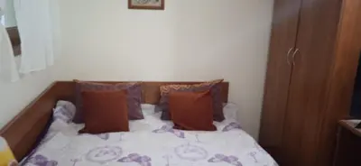a bed with pillows on it in a bedroom at Пампорово Студио М хотел в Росица in Pamporovo