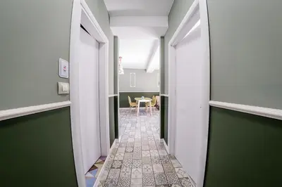 a hallway with green and white walls and a table at Sofia Rococo Life Apartments in Sofia