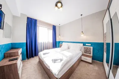 a bedroom with a large bed and blue walls at Sofia Rococo Life Apartments in Sofia
