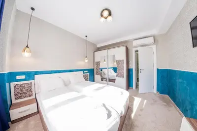 a bedroom with a large white bed and blue walls at Sofia Rococo Life Apartments in Sofia