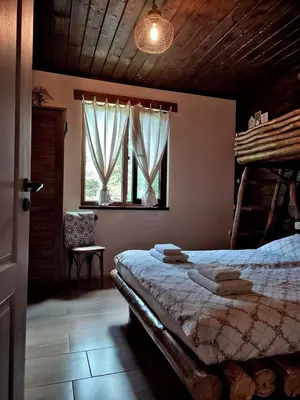 a bedroom with a bed and a window at Вила Приказка in Tsar Kaloyan