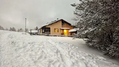 a house in the snow with its lights on at Вила Приказка in Tsar Kaloyan