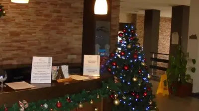 a christmas tree in a restaurant with a christmas decoration at Stylish Studio Apart Aspen Golf Resort in Razlog