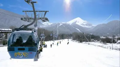 a ski lift with skiers on a snowy mountain at Stylish Studio Apart Aspen Golf Resort in Razlog