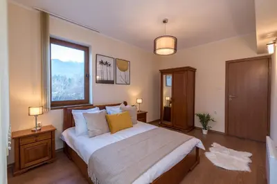 a bedroom with a large bed and a window at Charming Ski Apartments Near Gondola & Bar Street, Cedar Lodge 1 Complex in Bansko