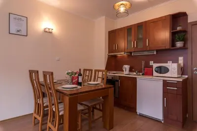 a kitchen with a table and chairs and a microwave at Charming Ski Apartments Near Gondola & Bar Street, Cedar Lodge 1 Complex in Bansko