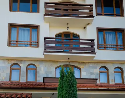a building with balconies and a tree in front of it at Charming Ski Apartments Near Gondola & Bar Street, Cedar Lodge 1 Complex in Bansko