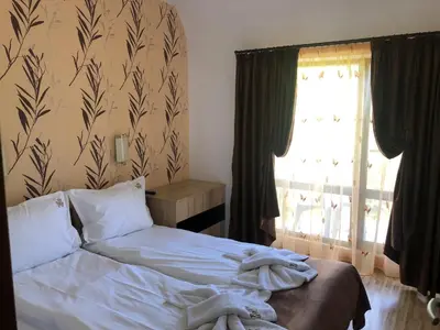 a bedroom with a bed with white sheets and a window at Fantasy Apartment 15 комплекс Фантазия, Хисаря in Hisarya