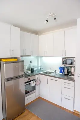 a kitchen with white cabinets and a stainless steel refrigerator at City View Apartment With 2 Bedrooms and Free Garage in Blagoevgrad