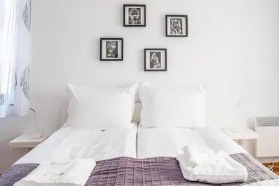 a bedroom with a bed with white sheets and pillows at City View Apartment With 2 Bedrooms and Free Garage in Blagoevgrad