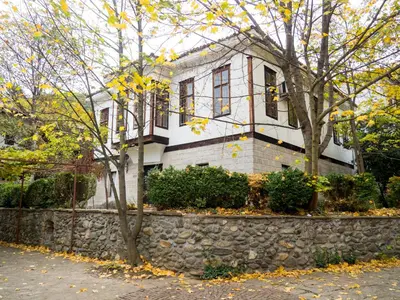 a white house with a stone wall at City View Apartment With 2 Bedrooms and Free Garage in Blagoevgrad