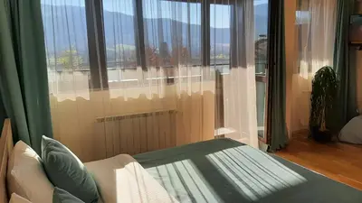 a room with a bed and a large window at Studio- apartament Lake View Pravets Golf Resort in Pravets