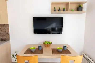 a dining room table with two chairs and a tv at Studio Talisman II in Sofia