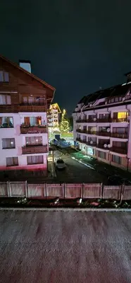 two tall buildings in a parking lot at night at Lucy's Apartments Emerald in Bansko