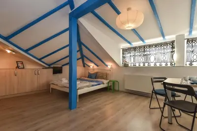 a room with a bed and a table and chairs at The Ivy House - A Cozy Attic near the City Center by Flat Mаnager in Sofia