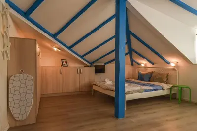 a bedroom with a bed with a blue pole at The Ivy House - A Cozy Attic near the City Center by Flat Mаnager in Sofia