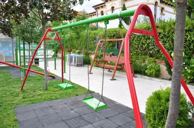 a playground with red and green swings at Elegance Spa Hotel in Ognyanovo
