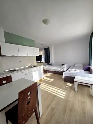 a kitchen and living room with two beds in a room at Elegance Spa Hotel in Ognyanovo