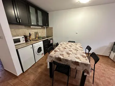 a kitchen with a table with chairs and a microwave at Private apartment in Prespa in Bansko