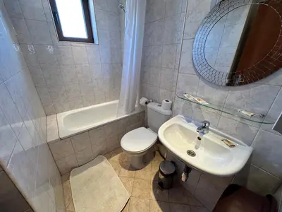 a bathroom with a toilet and a sink and a mirror at Private apartment in Prespa in Bansko
