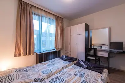 a bedroom with a bed and a desk and a window at Charming, Fully-furnished, 2-bedroom apartment by Flat Mаnager in Bansko