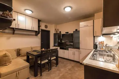 a kitchen and living room with a couch and a table at Charming, Fully-furnished, 2-bedroom apartment by Flat Mаnager in Bansko