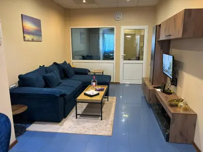 a living room with a blue couch and a table at KCT Downtown Apartment in Sofia