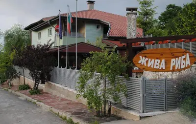 a restaurant with a sign in front of a building at Discret Hotel & Restaurant in Vladaya