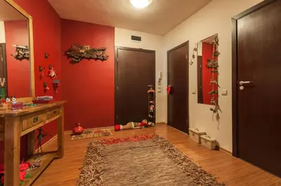 a room with red walls and two doors and a rug at Bansko Royal 721 Apartment in Bansko