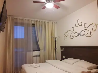 a bedroom with a bed with a ceiling fan and a window at Apartment in Belvedere Holiday Club 550 m from ski lift in Bansko