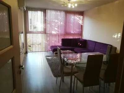 a living room with a purple couch and a table at Луксозен апартамент в идеалния център на град Сандански in Sandanski