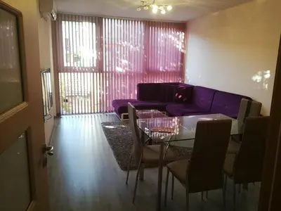 a living room with a purple couch and a glass table at Луксозен апартамент в идеалния център на град Сандански in Sandanski