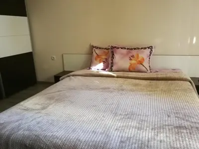 a bed with a pink pillow on top of it at Луксозен апартамент в идеалния център на град Сандански in Sandanski