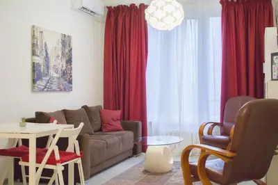 a living room with a couch and red curtains at Luxury suite near NDK and Viotosha blvd in Sofia