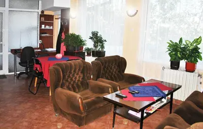 a living room with leather chairs and a table at Family hotel Zora in Sofia