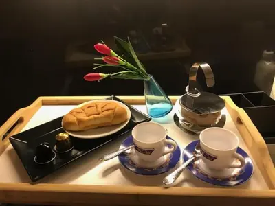 a tray with two cups and a plate with a sandwich and flowers at Riverside apart in Blagoevgrad