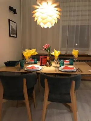 a dining room table with chairs and a chandelier at Riverside apart in Blagoevgrad