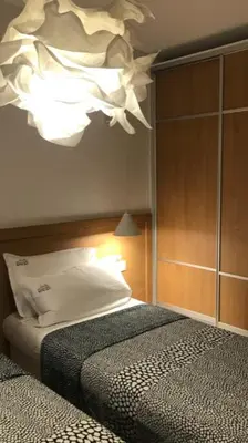 a bedroom with a bed and a chandelier at Riverside apart in Blagoevgrad