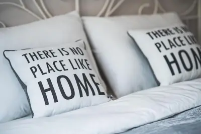 a white couch with pillows saying there is no place like home at Gladstone suites in Plovdiv