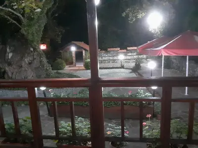 a view of a garden at night from a balcony at Семеен Хотел Хайдутите in Sandanski