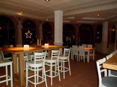 a restaurant with a bar with white chairs and tables at Cedar Lodge in Bansko