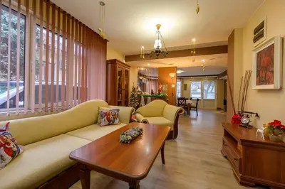 a living room with a couch and a table at Ахат- къща за гости in Kyustendil