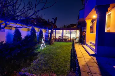 a house with a yard with a house at night at Ахат- къща за гости in Kyustendil