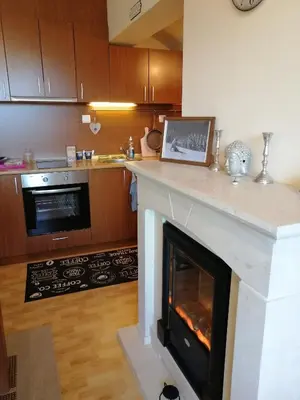 a living room with a fireplace in a kitchen at Apartment Viki Pamporovo in Pamporovo