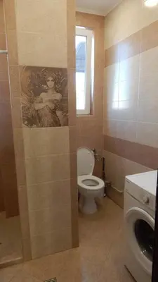 a bathroom with a toilet and a painting on the wall at Serdika station, bright and cozy apartment in Sofia