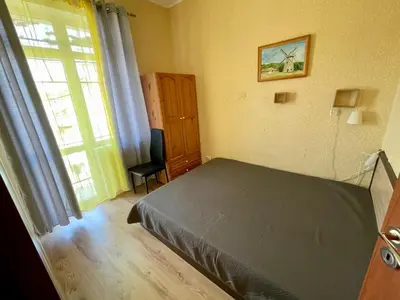 a bedroom with a bed and a window and a chair at Serdika station, bright and cozy apartment in Sofia