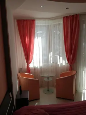 a bedroom with red curtains and a table and chairs at Apartment 33 in Hotel Iceberg in Borovets