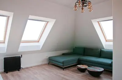 a living room with a couch and two windows at Apartment City View in Sofia